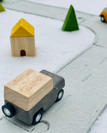 Close up of the PlanToys grey wagon toy car on the PlanToys rubber road and rail set