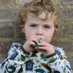 A child blowing into the PlanToys whale whistle toy. 
