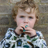 A child blowing into the PlanToys whale whistle toy. 