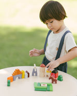 A child playing with the PlanToys Wooden Country Blocks. 