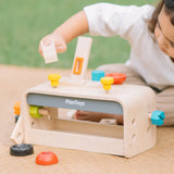 Child playing with the PlanToys little tool bench set.