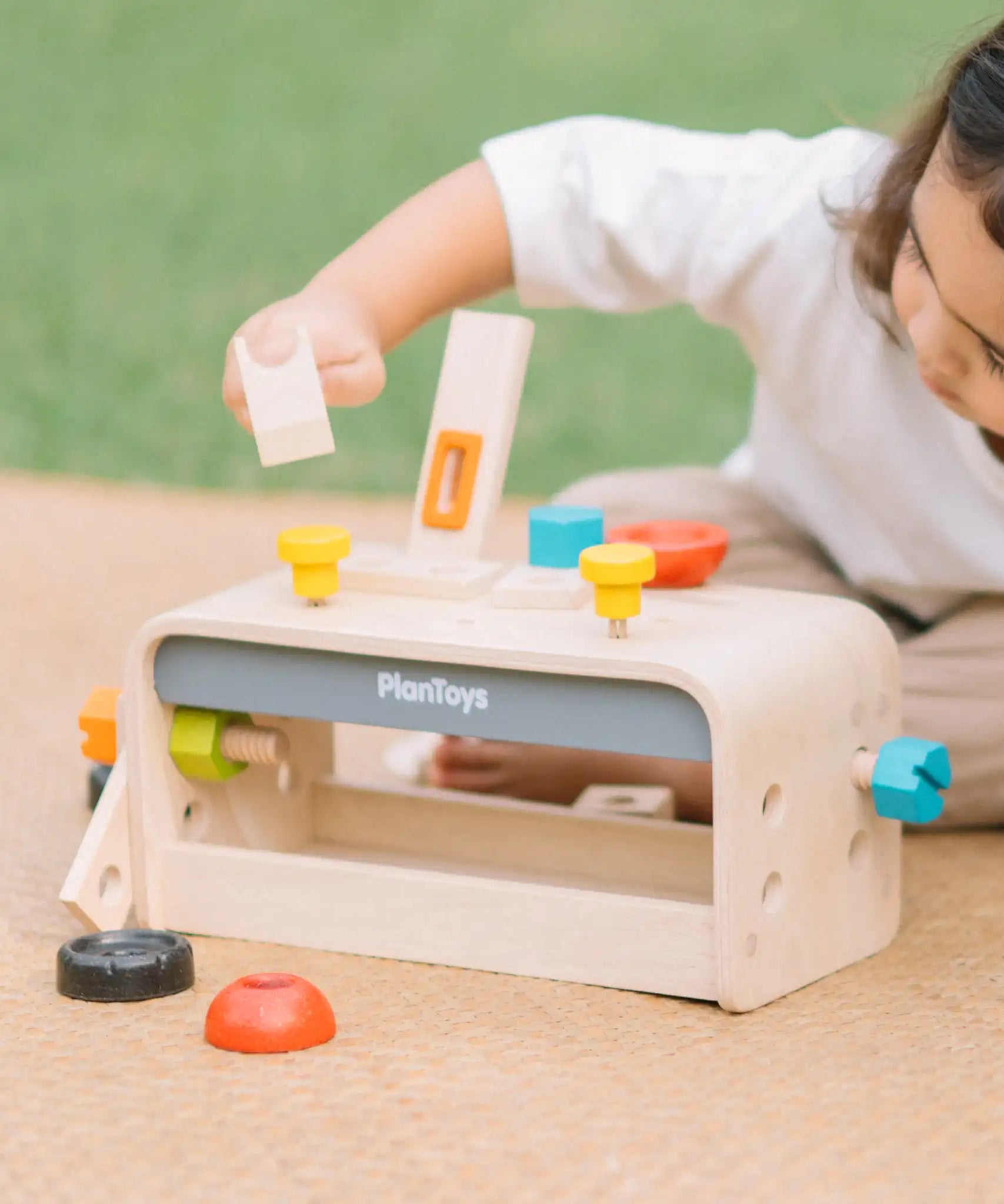 Child playing with the PlanToys little tool bench set.