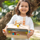 Child holding the PlanToys little tool bench set. 