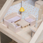 The sofas, chairs, lamp and coffee table from the PlanToys Living Room Dolls House Furniture set shown set up in a wooden dolls house. 