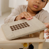 A close up of a child playing the with Plantoys wooden living room showing the sunlight roof being put on the support pillars