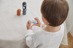 Young boy stacking pieces from the PlanToys wooden animal matching figures on a white table