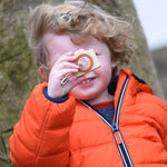 A child holding up the PlanToys Camera in front of their face. 