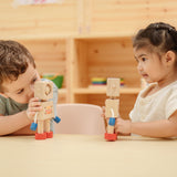 Two children sitting at a table playing with the  PlanToys Mood Bot Emotions Wooden Toy Robot. PlanToys range of toys are made from sustainably sourced rubberwood, we're proud stockists of PlanToys here at Babipur. 