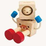 A PlanToys Mood Bot Emotions Wooden Toy Robot placed in a seated position. PlanToys range of toys are made from sustainably sourced rubberwood, we're proud stockists of PlanToys here at Babipur. 