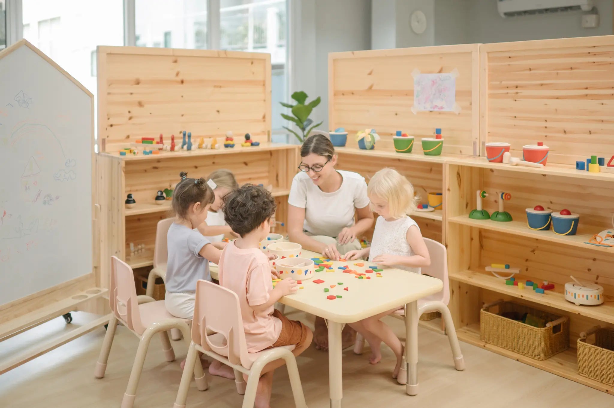 Children playing with the wooden pieces from the PlanToys Mosaic wooden pattern making toy.