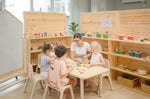Children playing with the wooden pieces from the PlanToys Mosaic wooden pattern making toy.