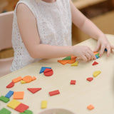 Child creating a colourful patterns using the wooden pieces from the PlanToys Mosaic wooden pattern making toy.