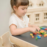 Child creating a colourful pattern using the wooden pieces from the PlanToys Mosaic wooden pattern making toy.