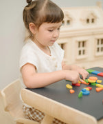 Child creating a colourful pattern using the wooden pieces from the PlanToys Mosaic wooden pattern making toy.