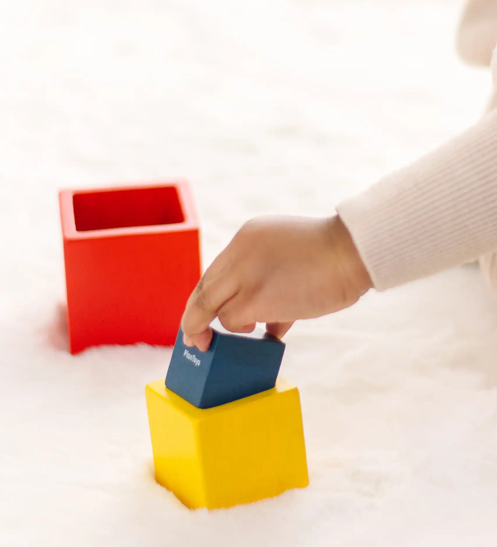 Child playing with the PlanToys nesting boxes.
