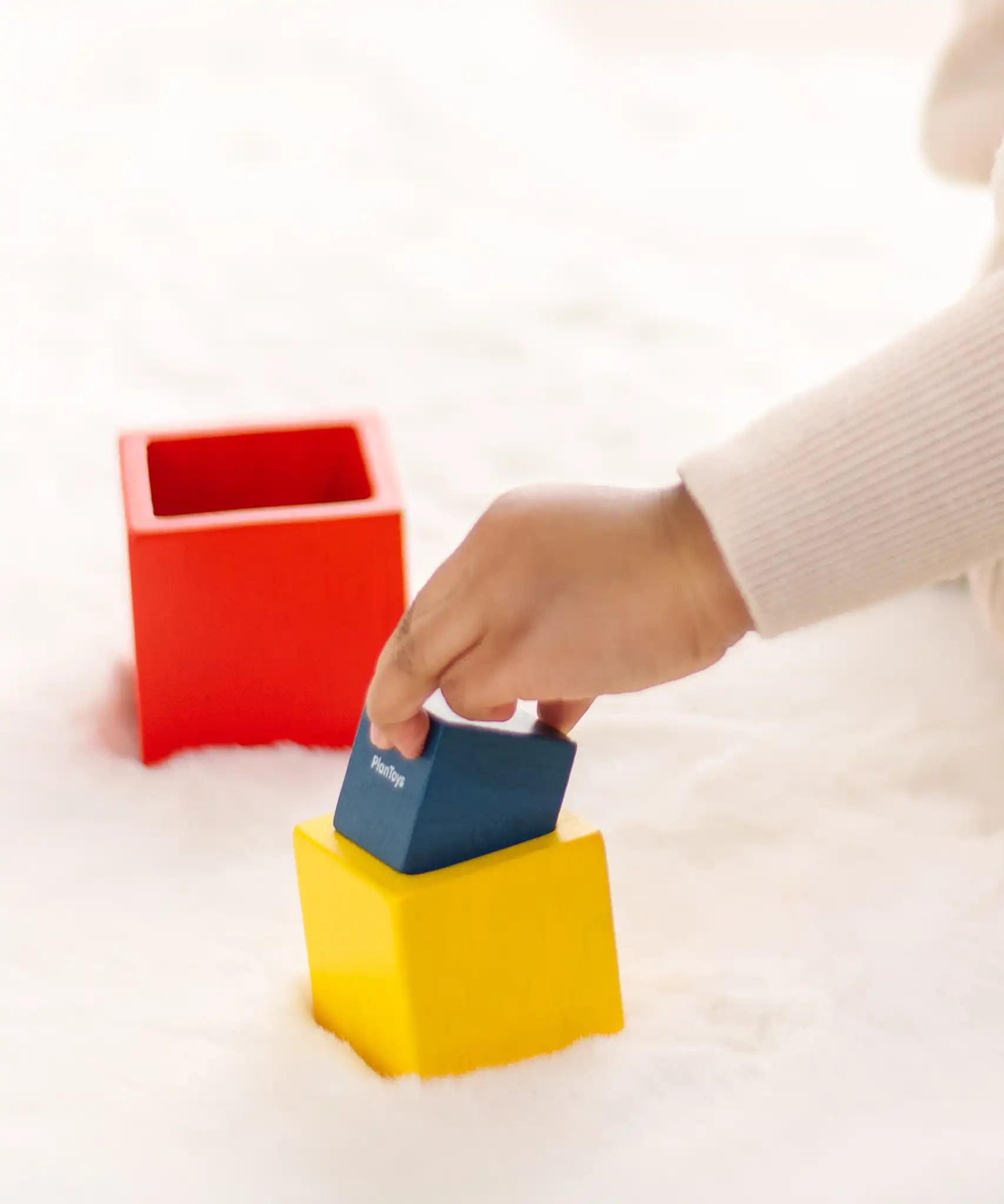 Child playing with the PlanToys nesting boxes.