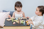 Two children sitting at the PlanToys desk playing with the PlanToys Pastel Blocks set. 