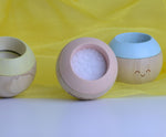 Plan Toys Pastel Sensory Tumbling placed on a yellow cloth. 
