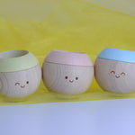 Plan Toys Pastel Sensory Tumbling all placed in a row showing their jolly little faces. 