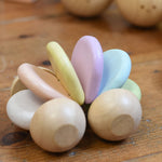 A PlanToys Pastel Car on a wooden floor. 