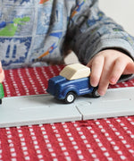 The blue pick up from the PlanToys Planworld Cars set being pushed along the PlanToys rubber road. 