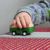 A close up of the green camper from the PlanToys Planworld Cars set being pushed along by a child's hand. 