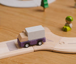Purple truck from the PlanToys PlanWorld vehicle wooden toy vehicles set placed on a wooden PlanToys road.