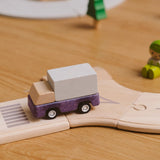 Purple truck from the PlanToys PlanWorld vehicle wooden toy vehicles set placed on a wooden PlanToys road.
