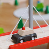 PlanToys wooden black taxi car toy vehicle on a PlanToys wooden bridge. 
