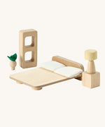 PlanToys wooden toy bedroom furniture for the planspace open dollhouse bedroom. Features a bed, bedside table, lamp, plant and shelving.