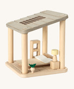 PlanToys Planspace bedroom - an open dollhouse kitted out with a wooden bed, bedside table, lamp, plant and shelves.