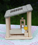 The PlanToys Planspace bedroom set placed on a patterned tablecloth.