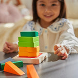 Close up of girl making a stack with the PlanToys plastic-free fraction blocks set