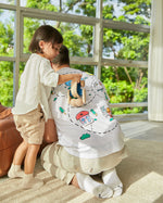 Man kneeling down with a child pushing the PlanToys wooden sensory roller vehicle toy across his back