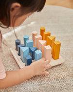 Close up of young child playing with the PlanToys plastic-free wooden geometric peg board