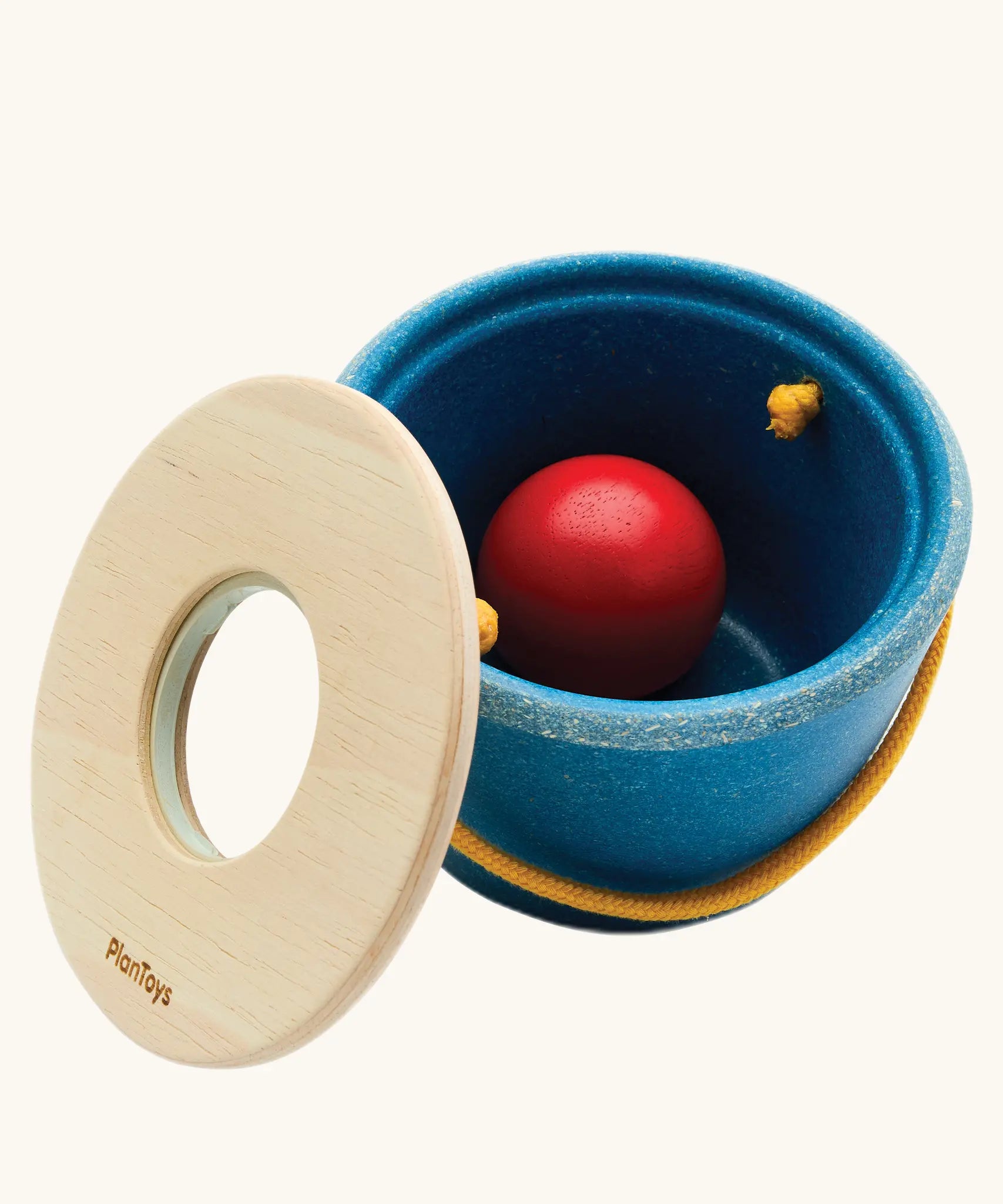 Toddler posting the red ball through the bucket lid