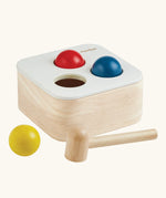 PlanToys punch and drop bin wooden pounding toy. Wooden box with three slots on the top, red, yellow and blue balls with a wooden hammer.