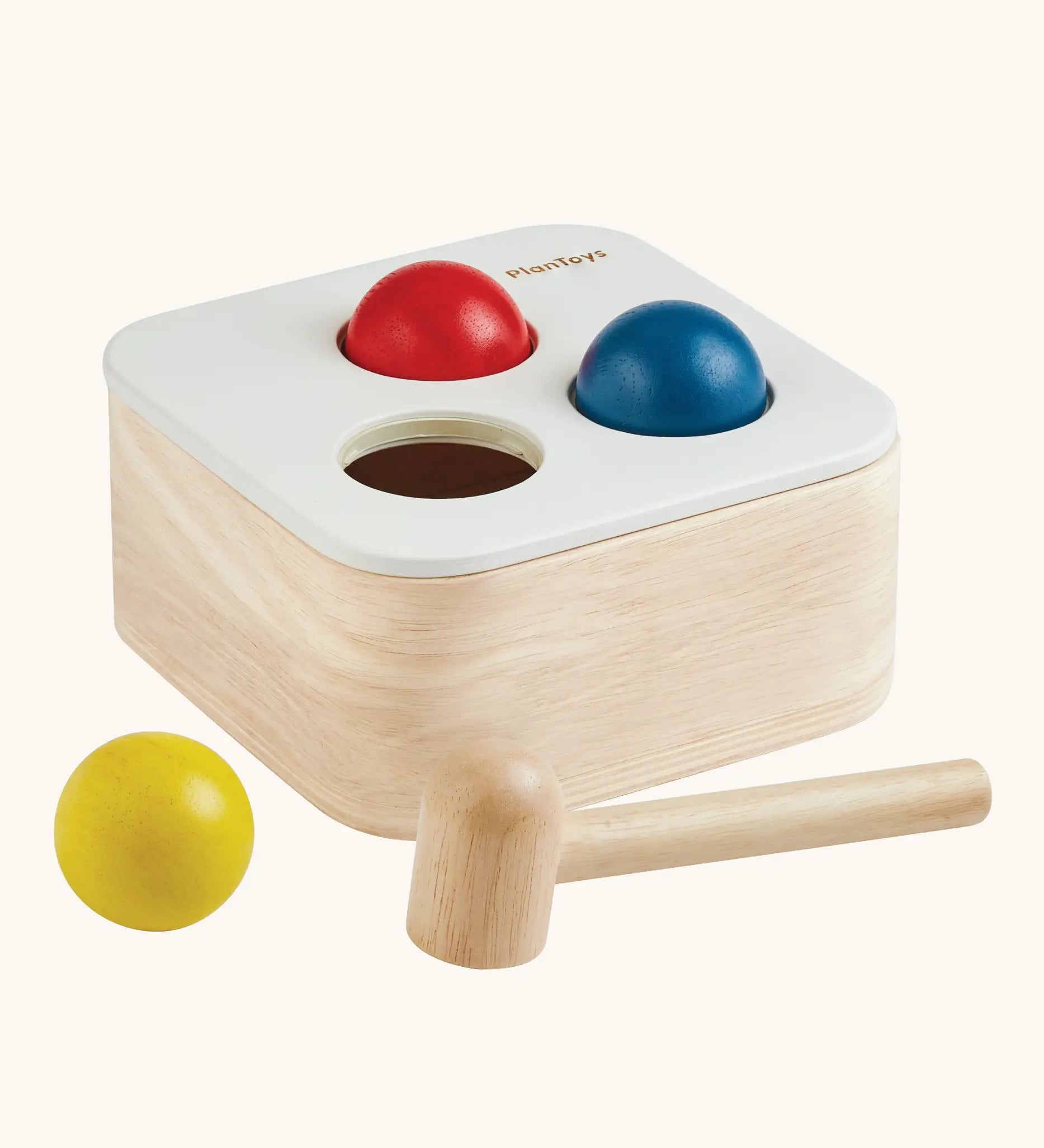 PlanToys punch and drop bin wooden pounding toy. Wooden box with three slots on the top, red, yellow and blue balls with a wooden hammer.