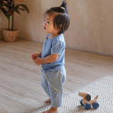 Child pulling the PlanToys push and pull puppy wooden toy along with the string attached.