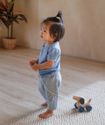 Child pulling the PlanToys push and pull puppy wooden toy along with the string attached.