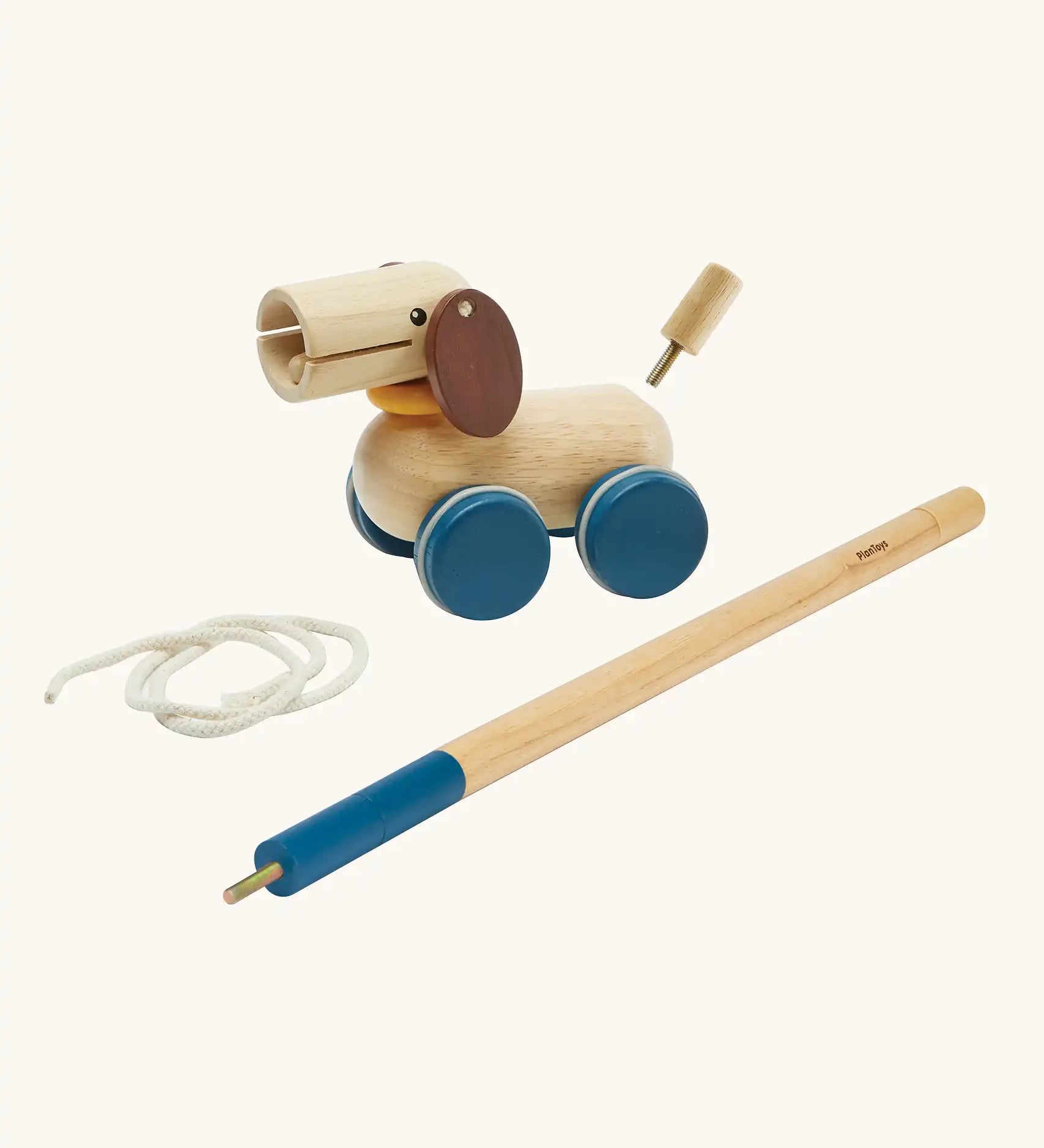 PlanToys push and pull puppy wooden toy. Wooden dog with brown ears and blue wheels that comes with a sting and a screw in stick so that it can be either pulled or pushed along. 