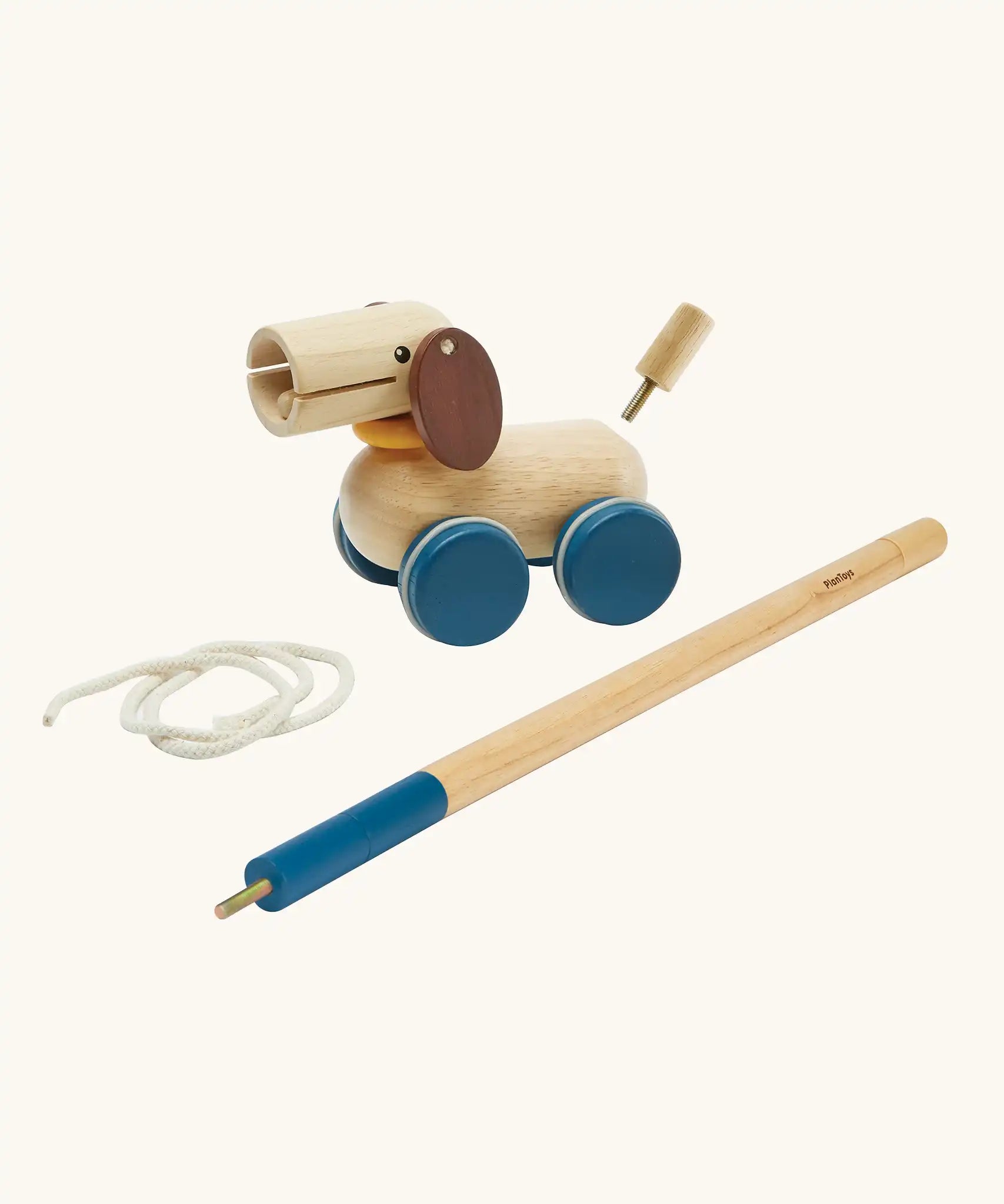 PlanToys push and pull puppy wooden toy. Wooden dog with brown ears and blue wheels that comes with a sting and a screw in stick so that it can be either pulled or pushed along. 