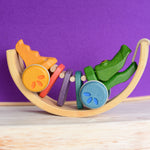 A Plan Toys Rainbow Alligator placed inside of a Grimm's rainbow arch.