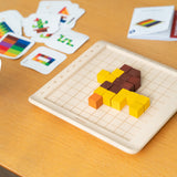 A lion  shape created using the PlanToys 100 Rainbow Counting Cubes, the card with the lion pattern can be seen at the side. 