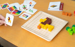 A lion  shape created using the PlanToys 100 Rainbow Counting Cubes, the card with the lion pattern can be seen at the side. 