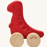PlanToys dino rex wooden car toy. A red coloured, wooden tyrannosaurus rex dinosaur figure toy on wheels. PlanToys range of toys are made from sustainably sourced rubberwood, we're proud stockists of PlanToys here at Babipur. 