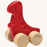 PlanToys dino rex wooden car toy. A red coloured, wooden tyrannosaurus rex dinosaur figure toy on wheels. PlanToys range of toys are made from sustainably sourced rubberwood, we're proud stockists of PlanToys here at Babipur. 