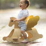 A child sitting on the PlanToys Rocking Pegasus toy. 