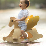 A child sitting on the PlanToys Rocking Pegasus toy. 
