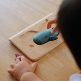 PlanToys Sea Life Puzzle with the pieces shown in the puzzle base on a wooden table. 